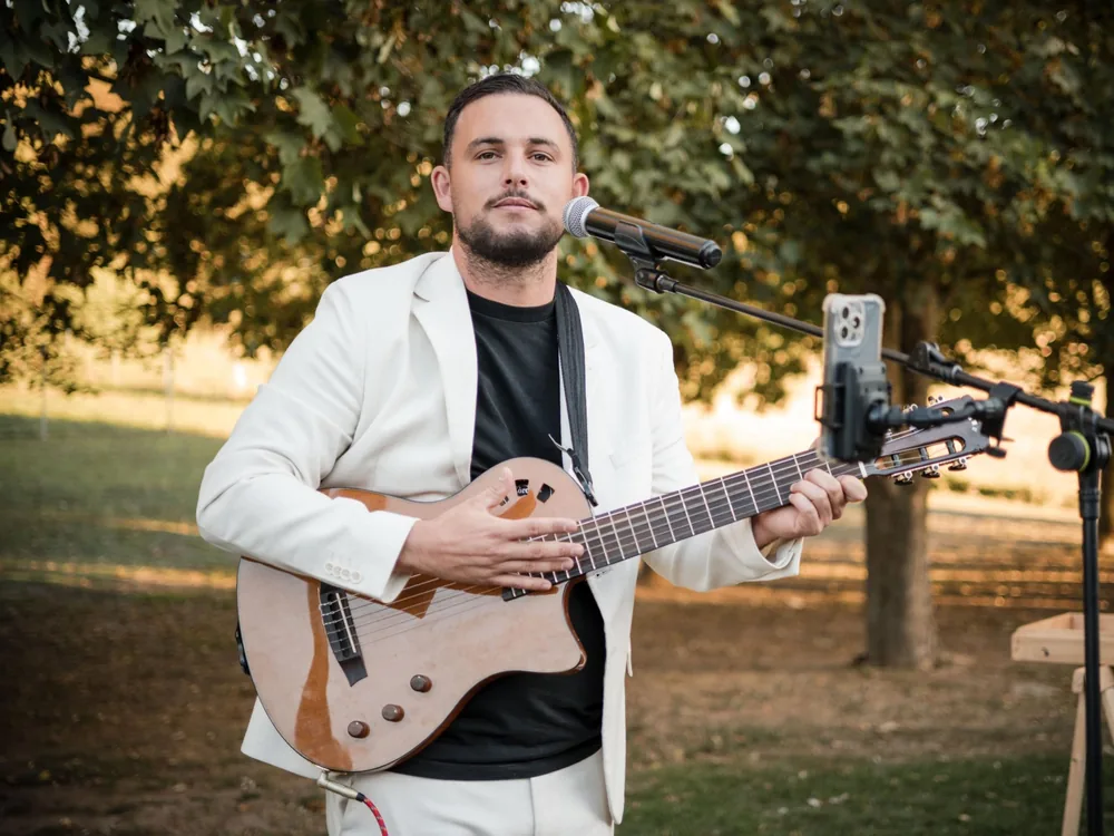 Thibaut Salvador en guitare-voix en extérieur pendant un cocktail